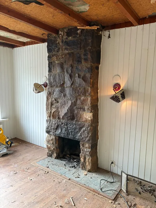 Grote natuurstenen schouw die uit de woonkamer wordt gehaald